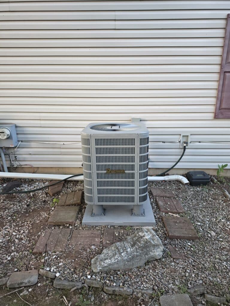 Outdoor AC condenser beside a home