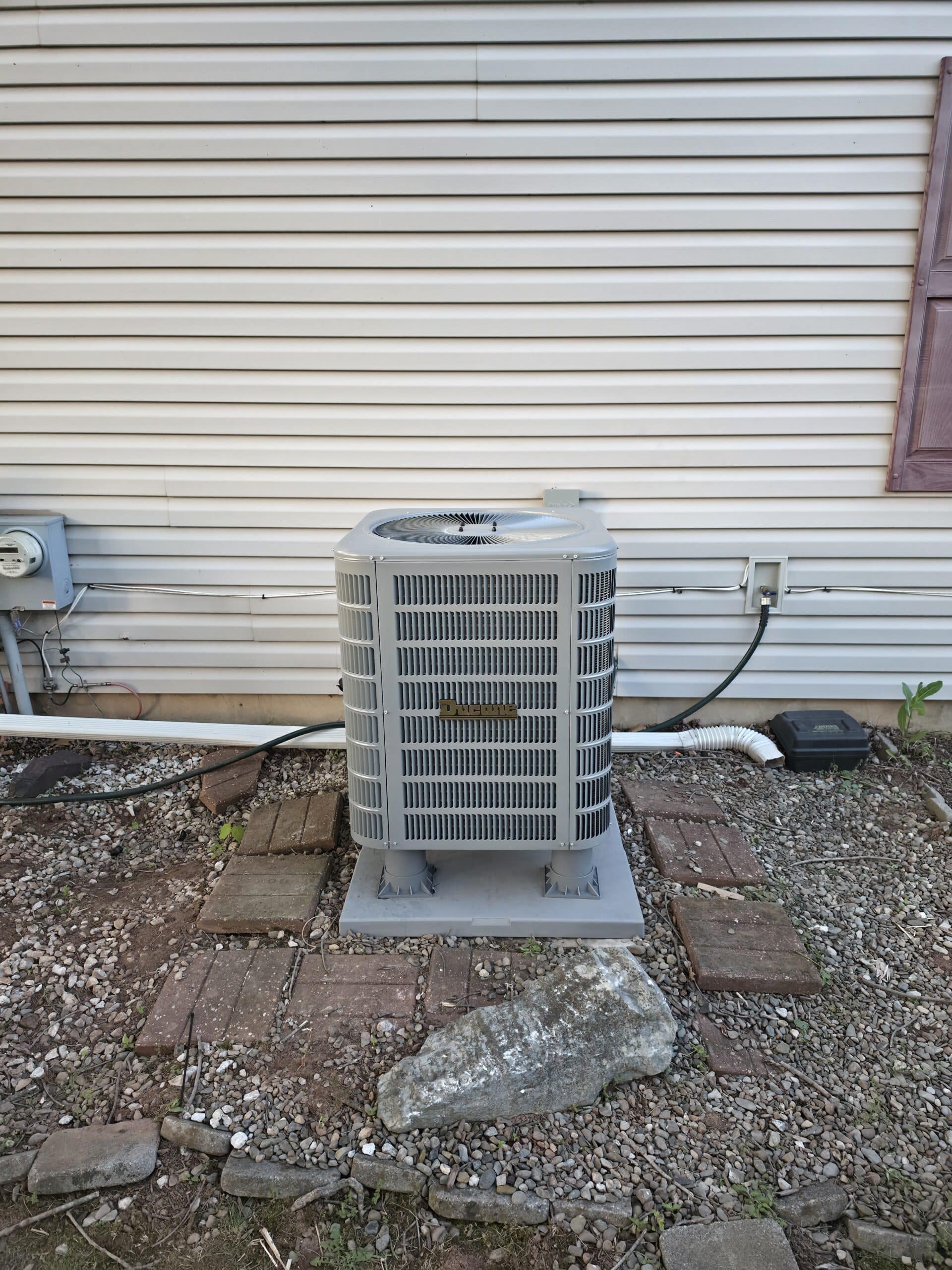 Outdoor AC condenser installed beside a home