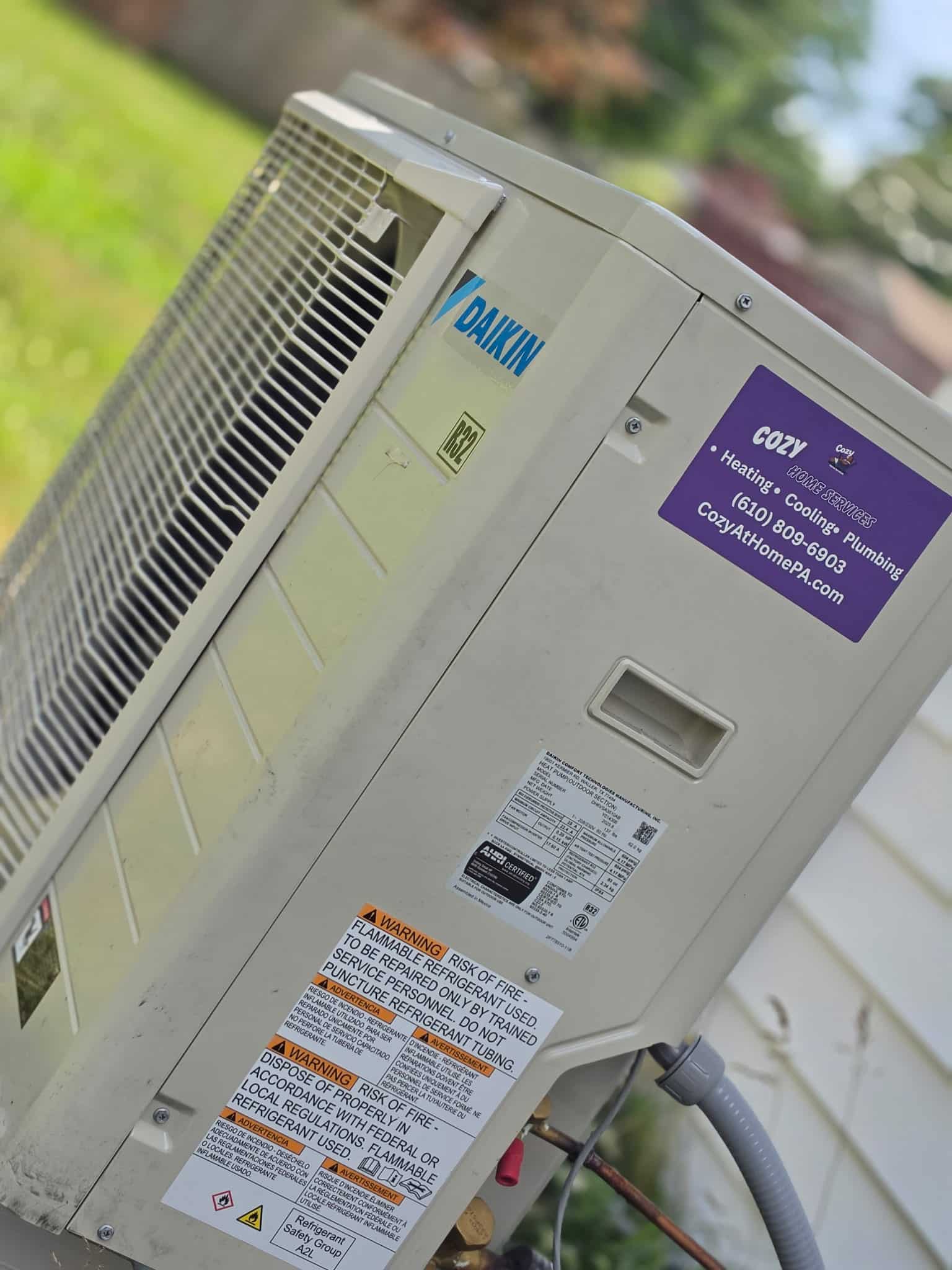 Close-up of a Daikin outdoor unit with a Cozy Home Services tag